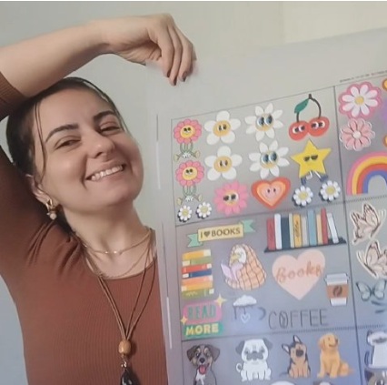 Fundadora da Creô Bags sorrindo ao lado de cartelas de stickers autoadesivos